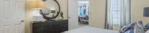 a bedroom with a bed and a dresser and a mirror