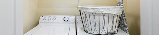 a washer and dryer in a laundry room with a basket on the top