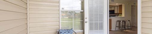 a patio with chairs and a door to a kitchen