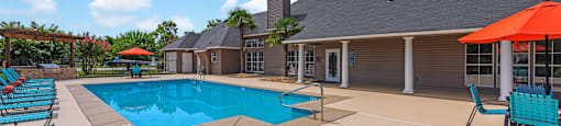 our resort style pool is next to our club house with chairs and umbrellas