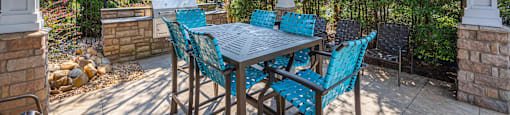 a covered patio with a dining table and chairs