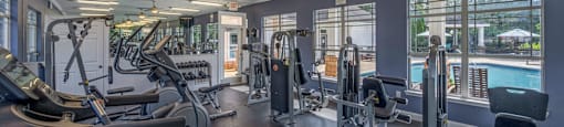 a gym with weights and cardio equipment and a pool