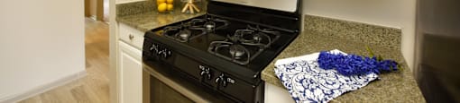 a kitchen with white cabinets and a black stove top oven
