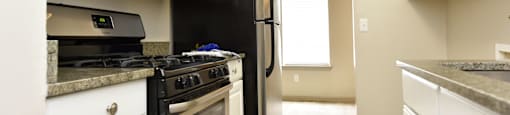 a kitchen with white cabinets and black appliances