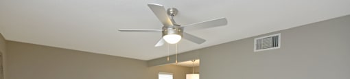 an empty living room with a ceiling fan