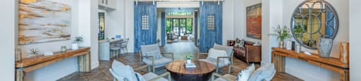 a living room with a table and chairs and a large window