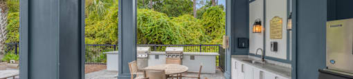 a patio with a table and chairs and a kitchen with blue walls