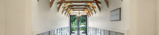a long hallway with wooden beams and mailboxes