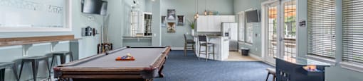 a game room with a pool table and a bar