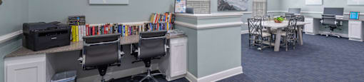 an office with blue carpeting and a desk with chairs