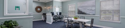 a conference room with a table and chairs and a ceiling fan