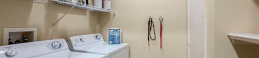 a washer and dryer in a laundry room with a door to the bathroom