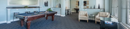 a game room with a pool table and a bar