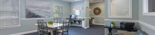 a conference room with a table and chairs and a ceiling fan