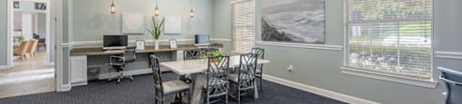 a conference room with a table and chairs and a ceiling fan