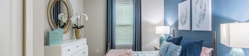 a bedroom with a bed and a dresser and a window
