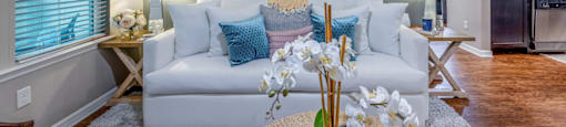 a living room with a couch and a table with flowers
