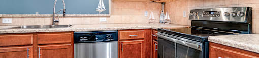 Apartments in Myrtle Beach SC - Lattitude @ The Commons - Spacious Kitchen with Stainless Steel Appliances, Woodstyle Flooring, and Matching Cabinets.