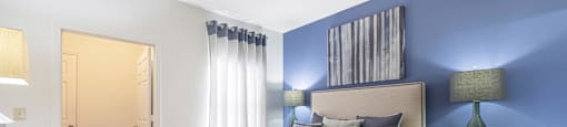 furnished bedroom with blue accent wall and a bed with white comforter