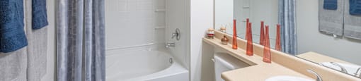 A bathroom with a white toilet, a white sink, a white bathtub, and a white shower.