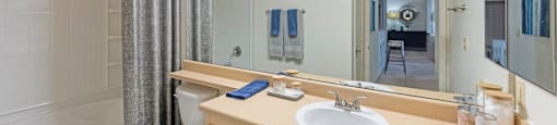 a bathroom with a large mirror and a toilet and a sink