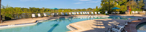 a resort style swimming pool with chairs around it