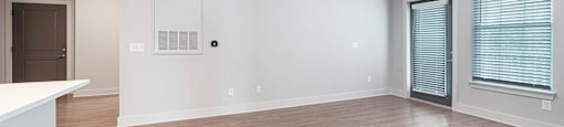 an empty living room with a ceiling fan and a window