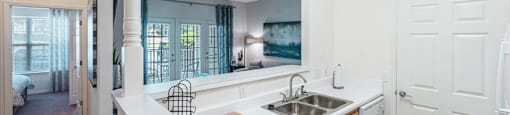 an open kitchen and living room with a sink and a window