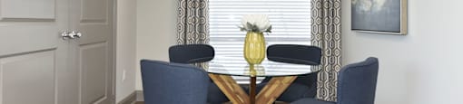 a dining room with a table and four chairs