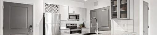A kitchen with a white marble countertop and a refrigerator.