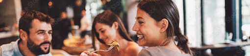 A group of people are sitting around a table eating food.