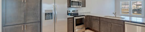 A kitchen with stainless steel appliances and wooden cabinets.
