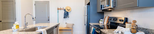 Altitude Raleigh kitchen with a granite countertop and stainless steel appliances.
