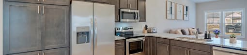 A kitchen with stainless steel appliances and wooden cabinets.