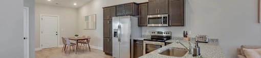A kitchen with a granite countertop and stainless steel appliances.