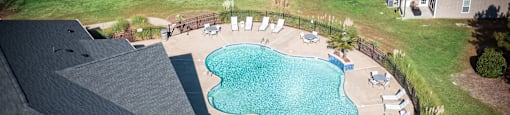 A small pool surrounded by a patio and deck.