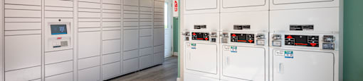a row of white utility lockers in a room with a ceiling fan