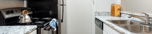 a kitchen with white cabinets and black appliances