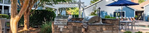 an outdoor kitchen with a grill and umbrella