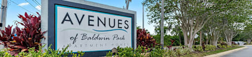 A sign for the Avenues of Baldwin Park stands in front of a street.