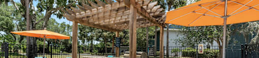 A patio with a table, chairs and a pergola.