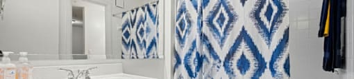 A bathroom with a blue and white shower curtain.
