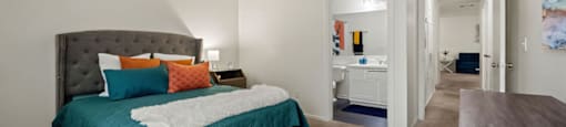 A bedroom with a bed and a mirror.
