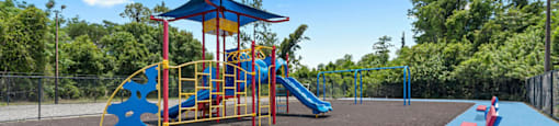 A playground with a blue slide and a red and yellow play structure.