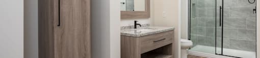 A bathroom with a sink, mirror, and shower at Liam at Hays Farm in Huntsville, Alabama