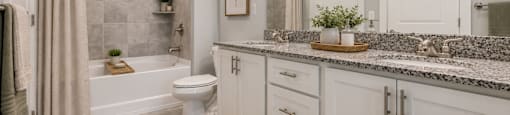 A bathroom with a toilet, sink, and shower.