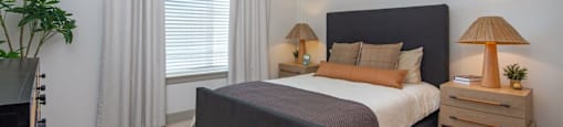 A bedroom with a large bed and two lamps at Liam at Hays Farm in Huntsville, Alabama