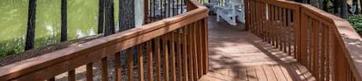 A gazebo is surrounded by trees and is situated on a wooden deck.