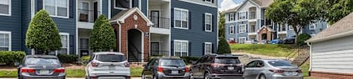 A row of cars are parked in front of a building.