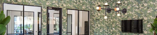 A pool table is in the middle of a room with a green wallpaper at Liam at Hays Farm in Huntsville, Alabama